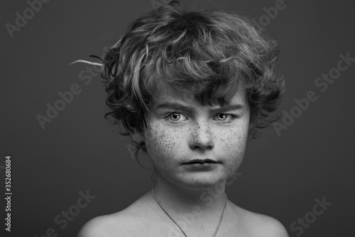 Cute curly seriously boy uncolored portrait