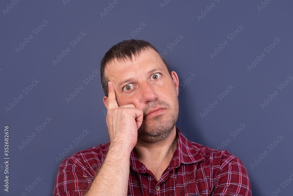 man surprised and thinks on a blue background man surprised and thinks on a blue background
