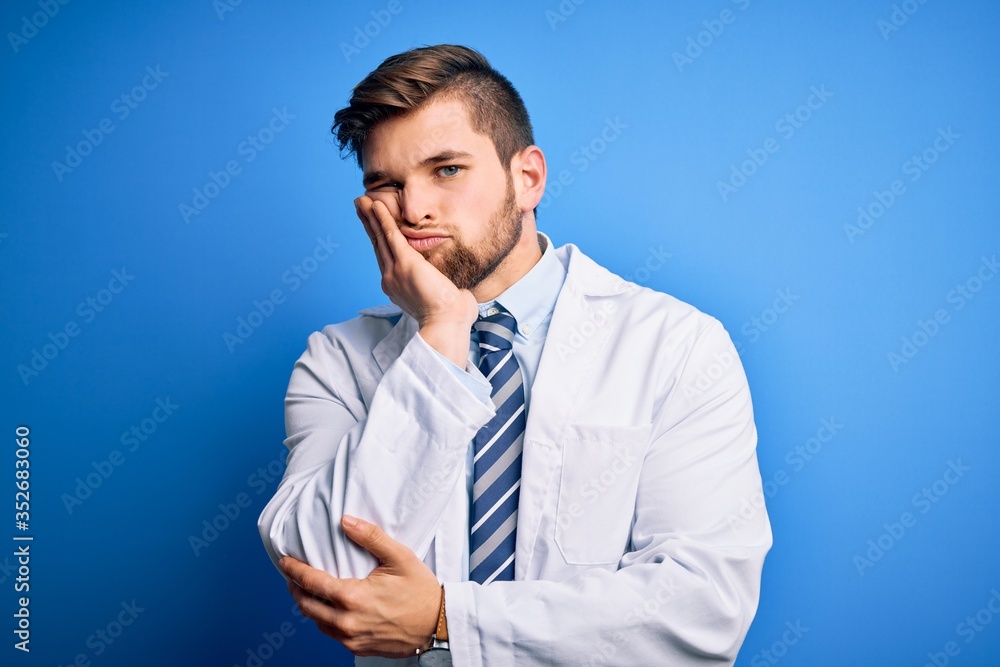 Young blond therapist man with beard and blue eyes wearing coat and tie over background thinking looking tired and bored with depression problems with crossed arms. Young blond therapist man with beard and blue eyes wearing coat and tie over background thinking looking tired and bored with depression problems with crossed arms.