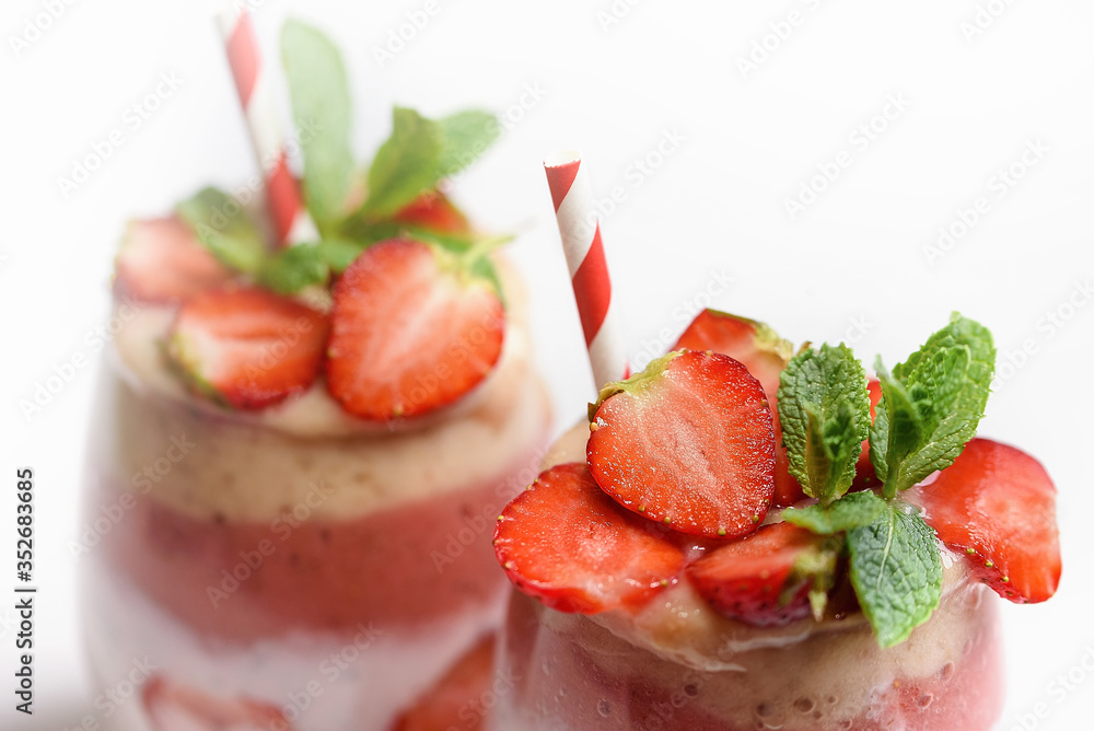 Glass of sweet delicious homemade layered smoothie dessert made from fruits and berries. delicious Strawberry banana milkshake, vegan raw food. Selective focus. Chia pudding with oatmeal Glass of sweet delicious homemade layered smoothie dessert made from fruits and berries. delicious Strawberry banana milkshake, vegan raw food. Selective focus. Chia pudding with oatmeal
