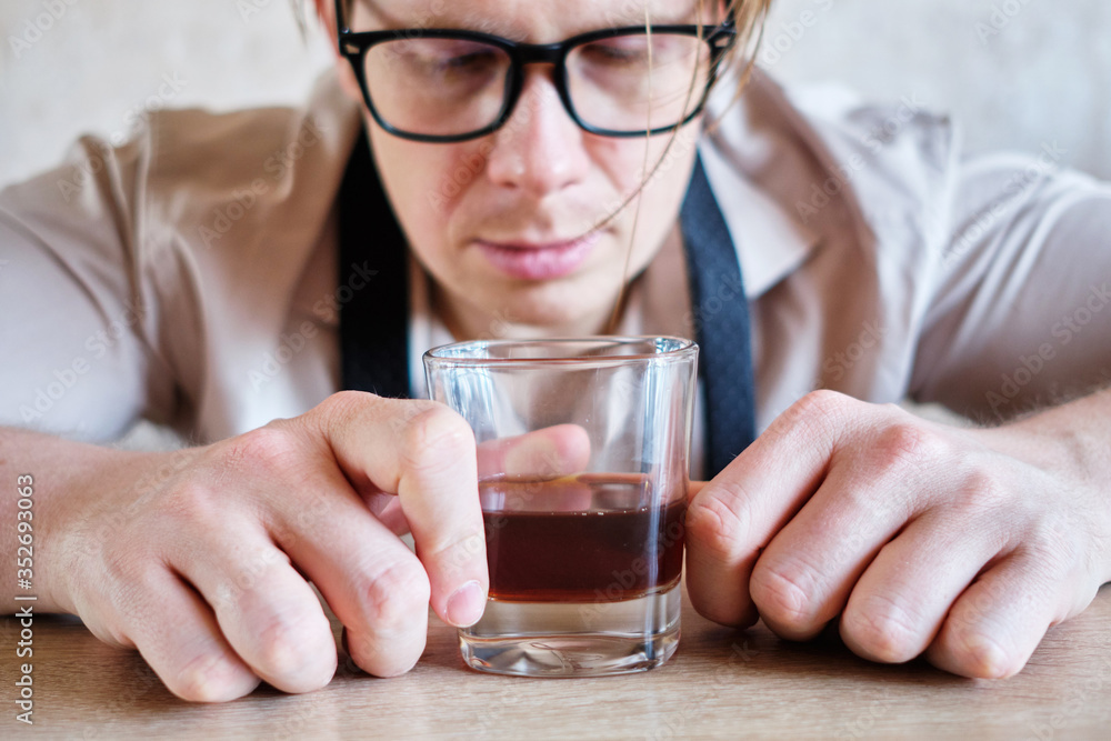 A man in a cafe with a glass of whiskey in after work A man in a cafe with a glass of whiskey in after work