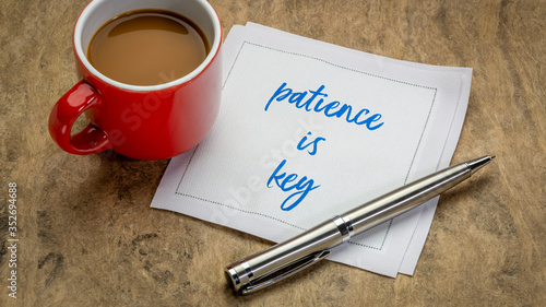 Foto patience is key inspirational note - handwriting on a napkin with a cup of coffe