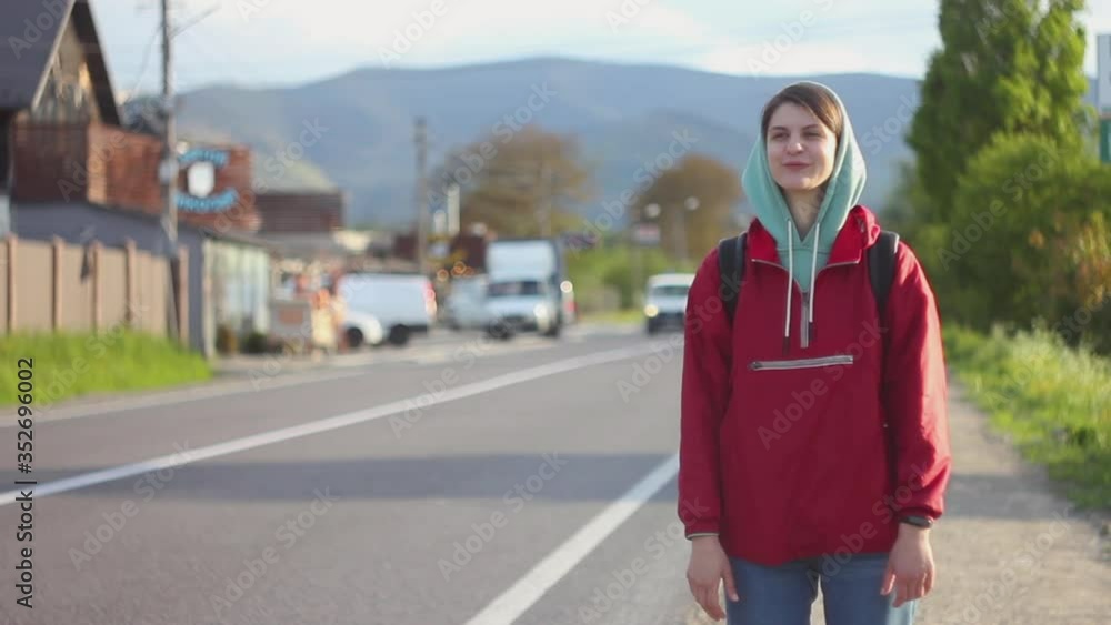 Woman traveler catches a car standing along the road. Female traveling auto stop Woman traveler catches a car standing along the road. Female traveling auto stop