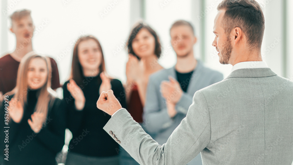 rear view. business man standing in front of applauding business team rear view. business man standing in front of applauding business team