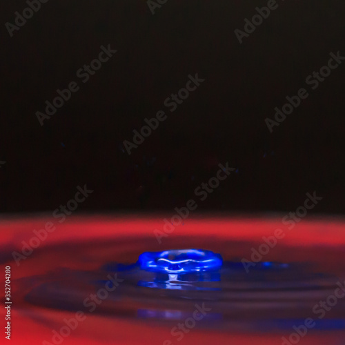 Blue water drop and splash in red color