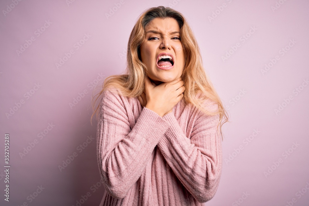 Young beautiful blonde woman wearing casual pink sweater over isolated background shouting and suffocate because painful strangle. Health problem. Asphyxiate and suicide concept. Young beautiful blonde woman wearing casual pink sweater over isolated background shouting and suffocate because painful strangle. Health problem. Asphyxiate and suicide concept.