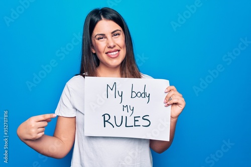 Fotografia Young beautiful woman asking for women rights holding paper with my body my rule