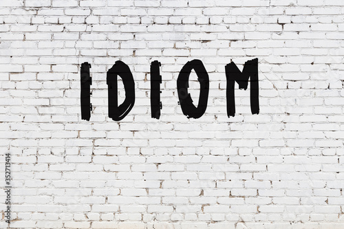 Obraz na płótnie Word idiom painted on white brick wall
