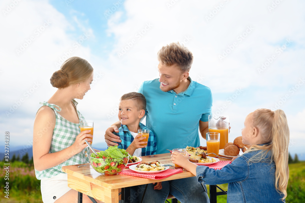 Happy family having picnic at table in park Happy family having picnic at table in park
