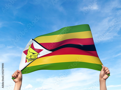 Two hands are holding a Zimbabwe flag - flowing through the wind. 3D Illustration.