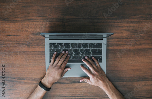 Men's hands in an electronic watch on a laptop keyboard