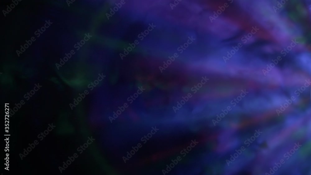 Bright multi-colored rays move in a stream of smoke and create beautiful flares on black background. Closeup. Slow motion. High speed camera Bright multi-colored rays move in a stream of smoke and create beautiful flares on black background. Closeup. Slow motion. High speed camera