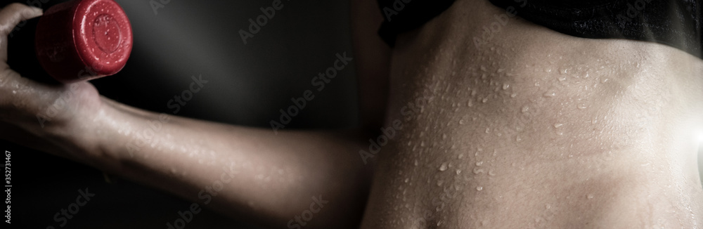 Fototapeta premium Fitness Model Lady woman sweaty sporty belly stomach after heavy exercise, working office girl workout sweat with dumbbell weight loss concept, dark studio background, black and white style