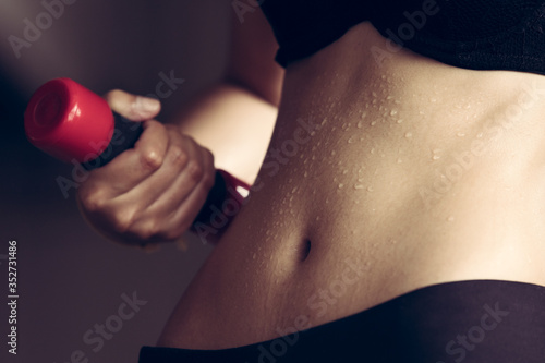 Fitness Model Lady woman sweaty sporty belly stomach after heavy exercise, working office girl workout sweat with dumbbell weight loss concept, dark studio background, black and white style