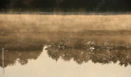 Fog over a forest lake on a Sunny summer morning. Moscow region. Russia. © Andrey