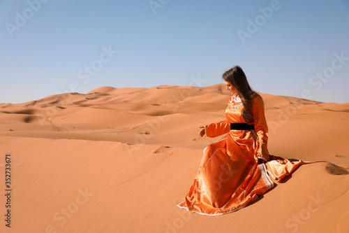 Schilderij op canvas A girl in a beautiful Moroccan dress. Merzouga Morocco.