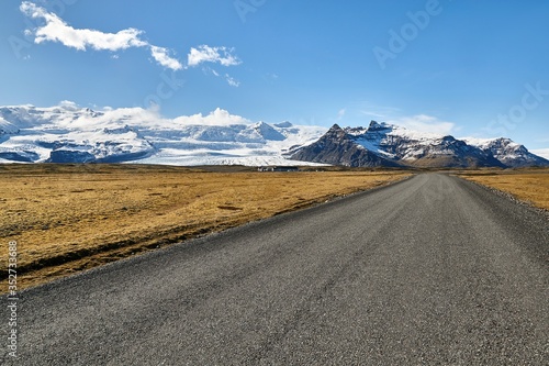 Gravel road in Iceland with mountains and glacier in the background