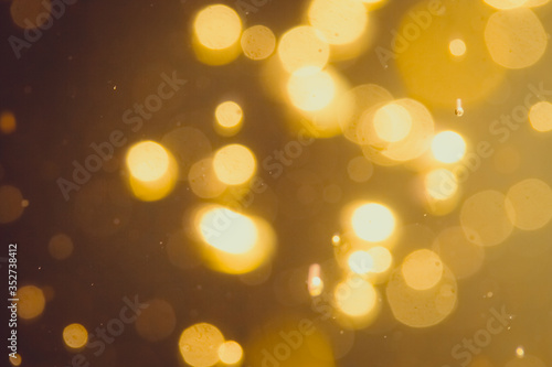 Dark Abstract Gold bokeh sparkle on black background