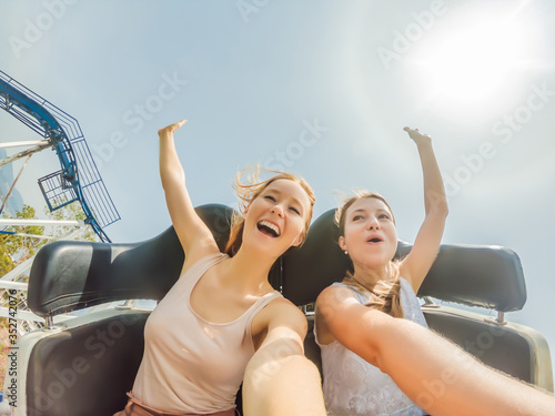 Fototapete Two happy girls having fun on rollercoaster