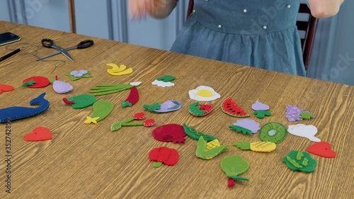 Designer makes, sews soft childrens toys from fabric. In the form of fruits