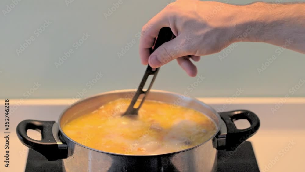 Slowly stir the boiling soup into the pot in a saucepan on the stove. Slowly stir the boiling soup into the pot in a saucepan on the stove.
