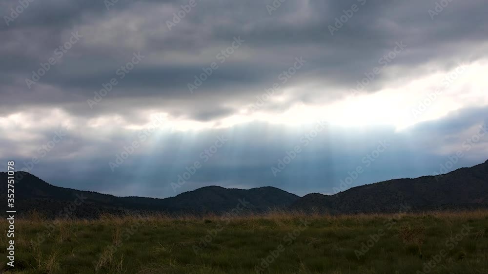 Sun rays shining though swirling dark clouds over Rocky Mountains, Colorado Sun rays shining though swirling dark clouds over Rocky Mountains, Colorado