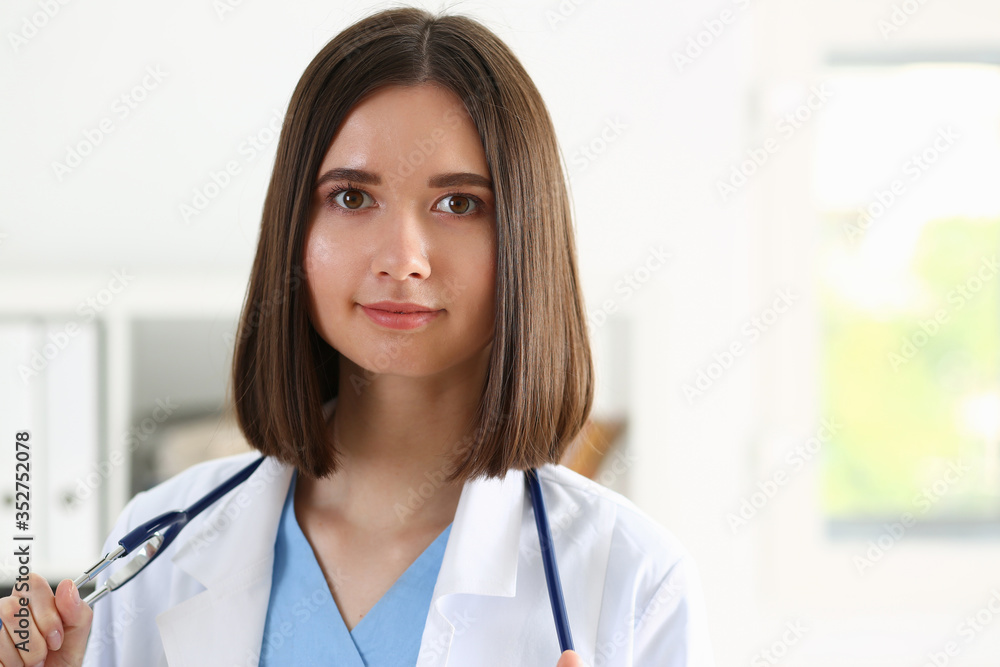 Beautiful smiling female doctor stand in office portrait Beautiful smiling female doctor stand in office portrait