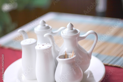 Flavoring white bottle set on table ( salt , pepper and toothpicks )