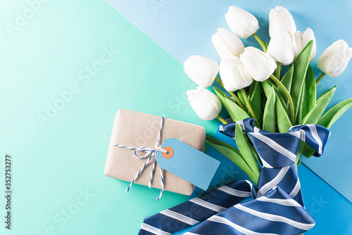 Happy Fathers Day background concept with blue necktie, gift box and greeting card   on bright pastel background.