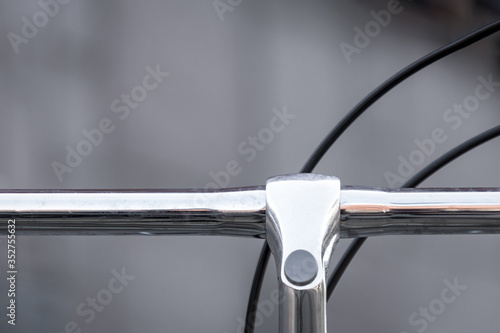 Detail einer Fahrradlenkstange aus Metall mit schwarzem Kabel