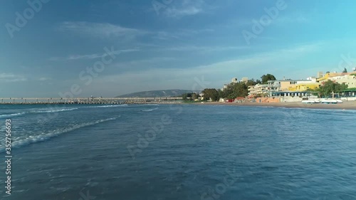 Low fast aerial backward drone view above sea water and waves breaking on beach shoreline, Chekka, Lebanon photo