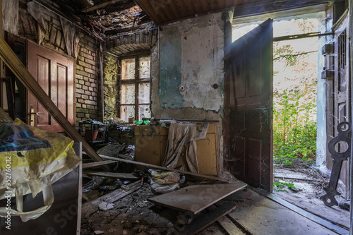 derelict room and open entrance door in a house