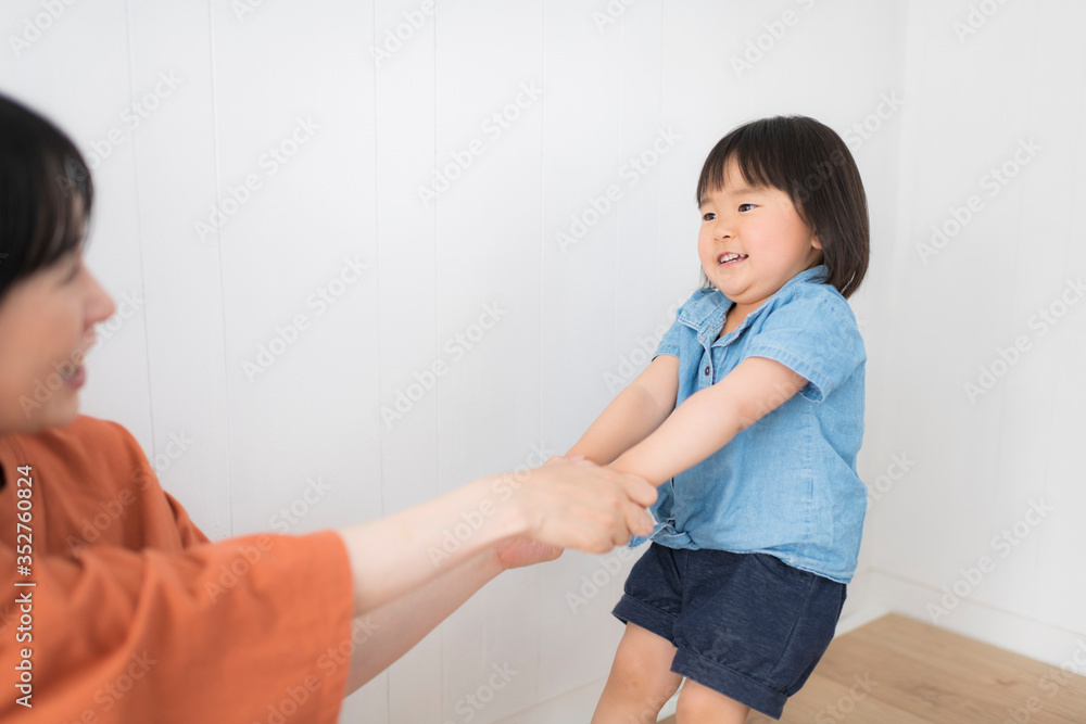 部屋で母親と遊ぶ元気な女の子