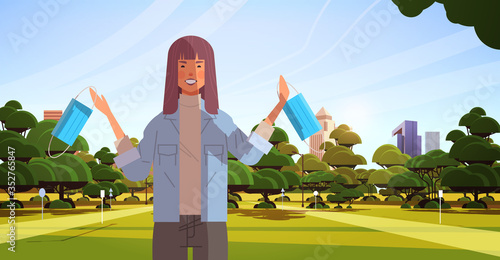woman holding medical mask coronavirus win defeated covid-19 girl celebrating victory over nCoV virus ending pandemic quarantine concept cityscape background horizontal portrait vector illustration