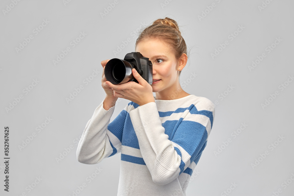 photography and people concept - smiling teenage girl in pullover with digital camera over grey background photography and people concept - smiling teenage girl in pullover with digital camera over grey background