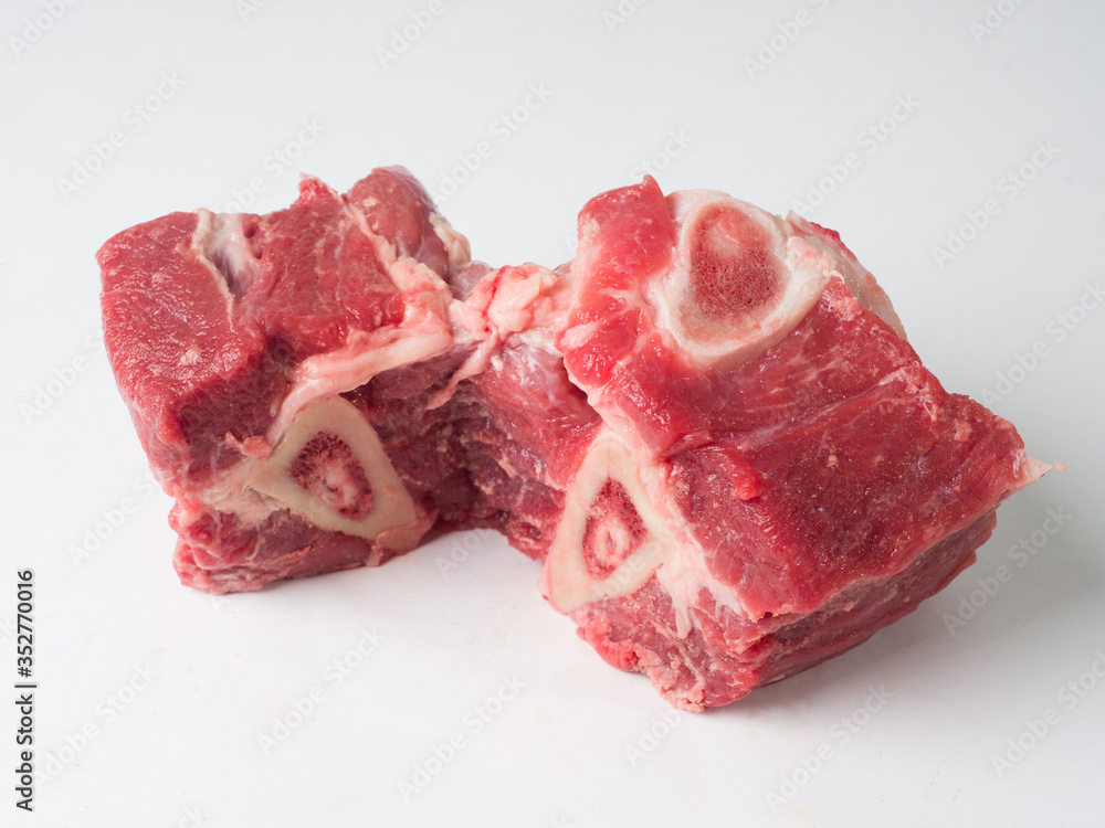 Pieces of fresh raw meat and beef bones on a white background. Ingredients for cooking