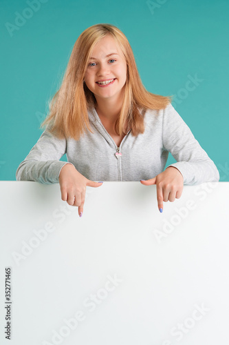 The girl looks out of the empty banner, pointing her fingers down at the white empty space