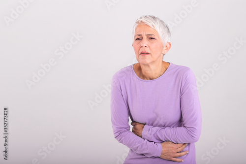 Unhealthy mature woman holding belly  feeling discomfort  health problem concept  unhappy older female sitting on bed  suffering from stomachache  food poisoning  gastritis  abdominal pain  climax