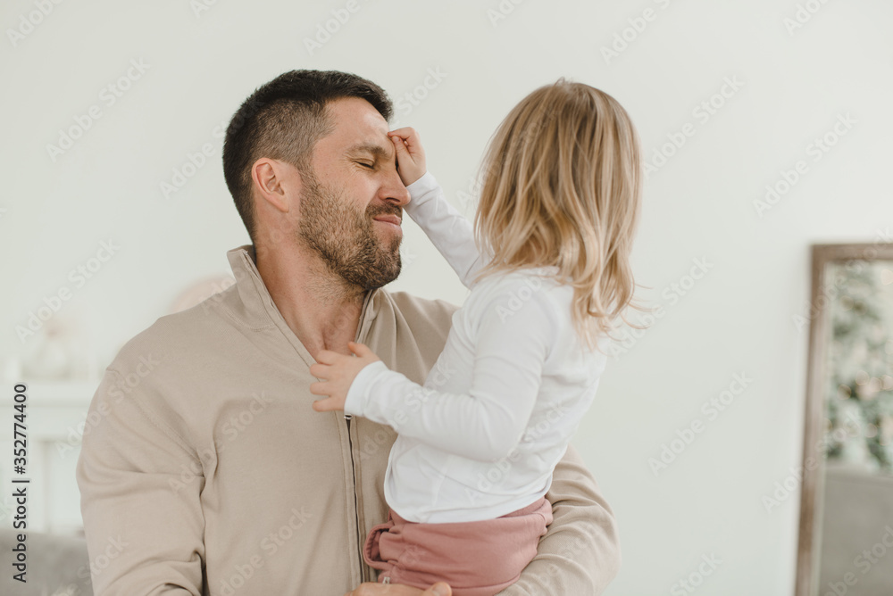Cute baby girl with her parents play in a minimalistic children's room. Cute baby girl with her parents play in a minimalistic children's room.