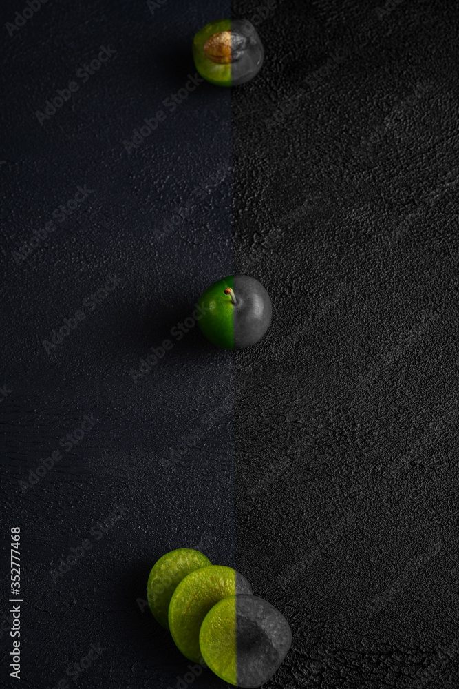 Green sour plum. Greengage on isolated on dark background. Colorful, black and white. Top view. Copy space for text message. Creative concept.