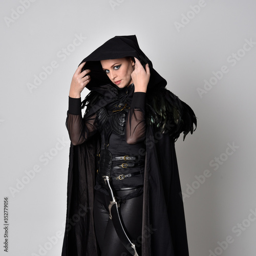 Canvas-taulu Close up fantasy portrait of a woman with red hair wearing dark leather assassin costume with long black cloak