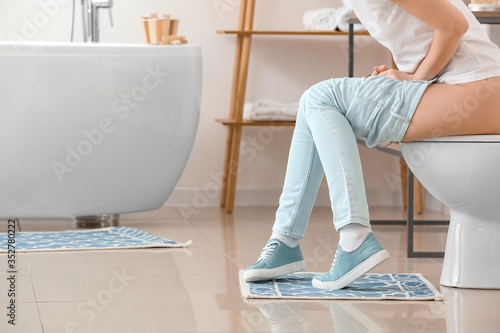 Young woman with hemorrhoid...