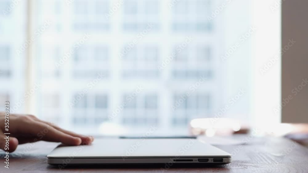 Close-up of hands of unrecognizable man turning off laptop and closing ...