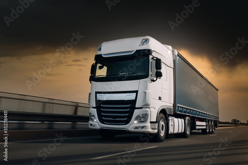 Obraz na plátně Semi-truck with cargo trailer driving at the hightway