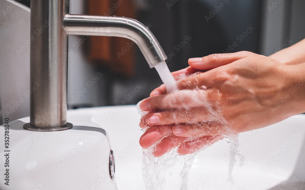 Φωτογραφία Woman cleaning and washing hands under the faucet in bathroom