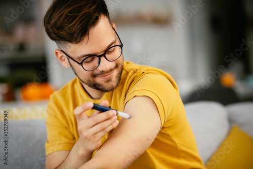 Young man giving himself an insulin shot at home
 photo