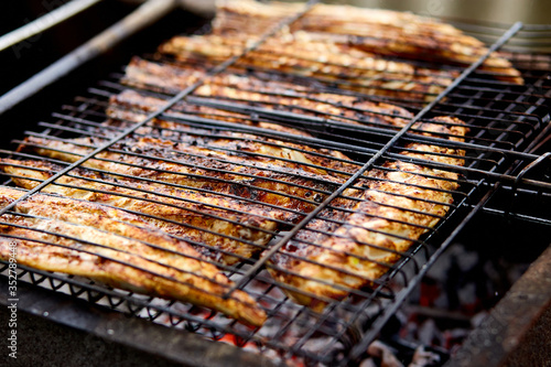 Grilled fish mackerel, cooked on the grill in the open air flow tasty and fresh food, picnic outdoor recreation. Barbeque in the garden in summer at home. photo