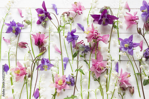 Flowers flat design. Floral pattern with pink and purple Aquilegia and Convallaria flowers. Flowers texture. Flat lay, top view