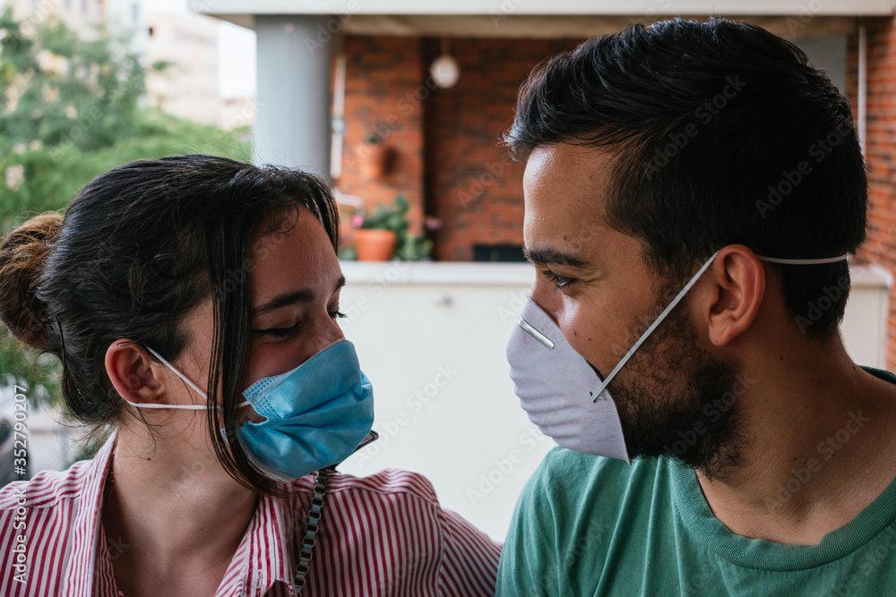 young couple talking with face masks in time of coronavirus