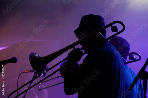 Jazz musicians performing in the French Quarter of New Orleans, Louisiana, with smoke and neon lights in the background.